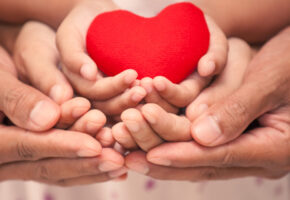 Red heart in child kid  mother and father hands in vintage color tone