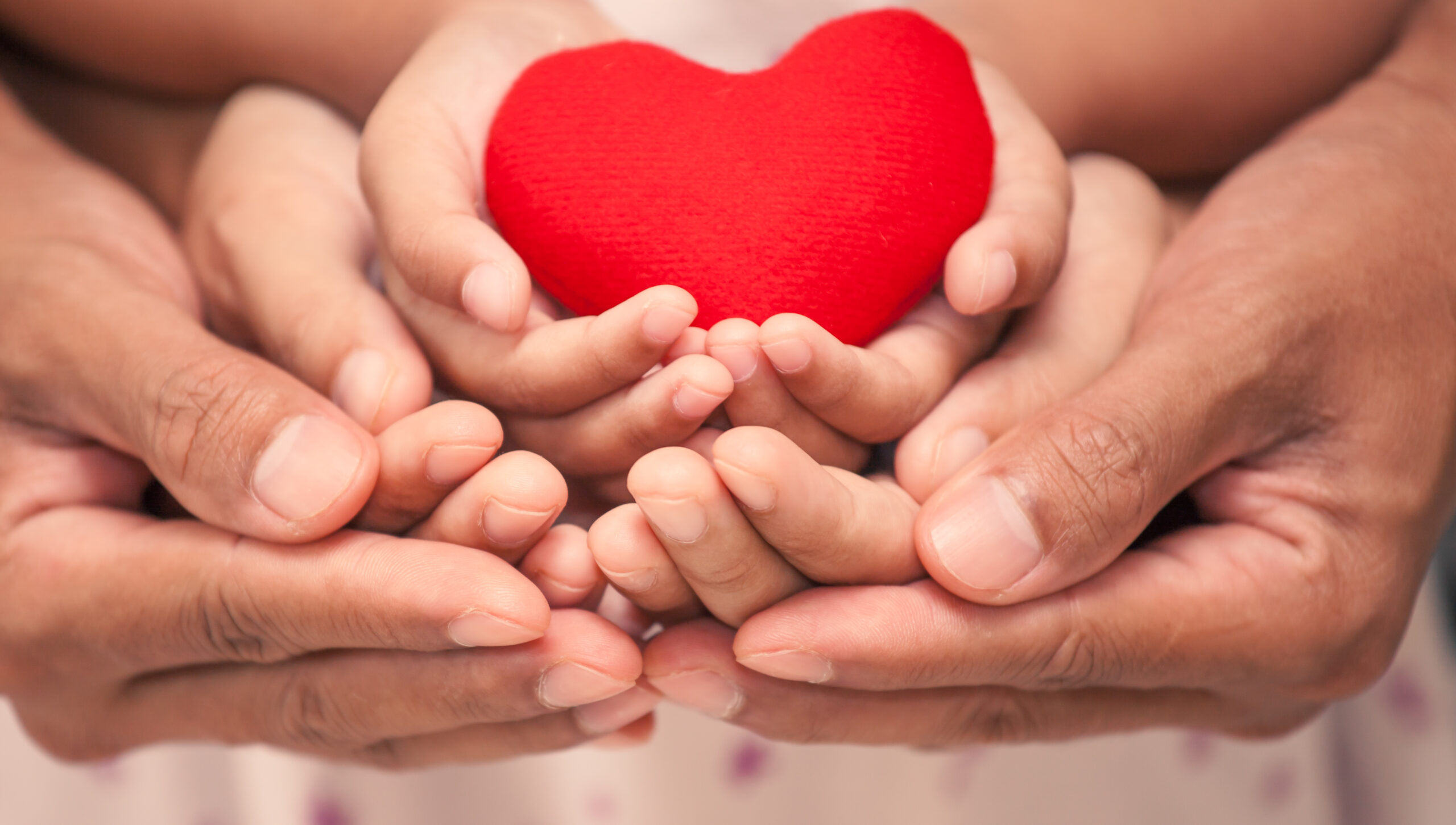 Red heart in child kid mother and father hands in vintage color tone Red heart in child kid mother and father hands in vintage color tone