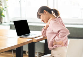 Business woman suffering from stiff shoulders