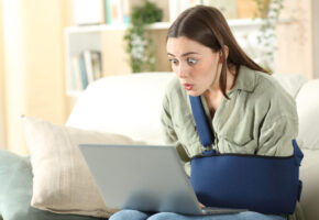 Surprised disabled woman cheking laptop at home