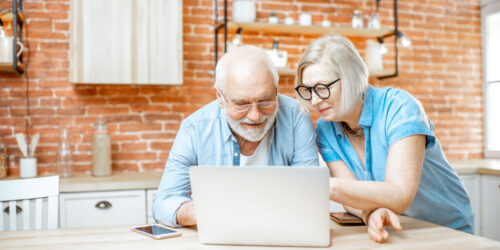 Senior couple with laptop at home