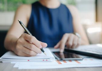 Businesswoman using smatphone for analysis maketing plan, Manager calculate financial report and graph chart.  Business, Finance and Accounting concepts