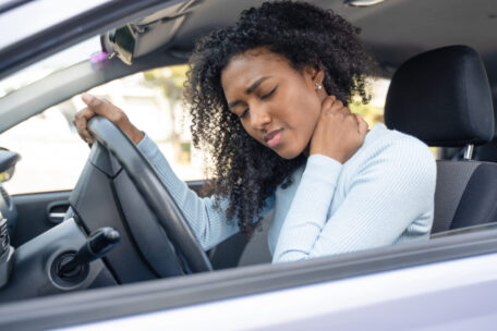 One black woman in the car with neck pain